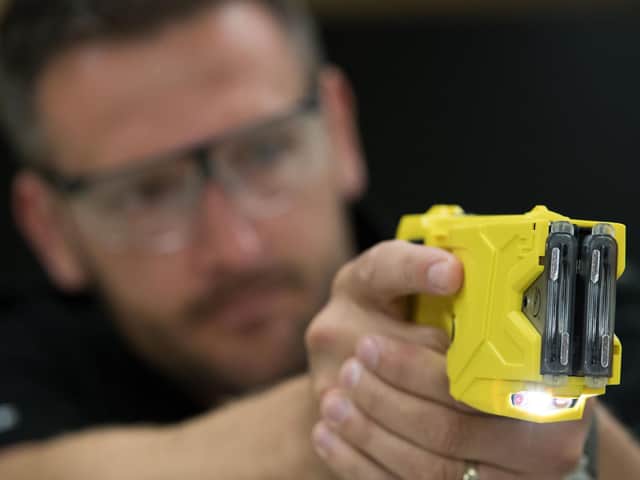 A police officer takes aim with a Taser