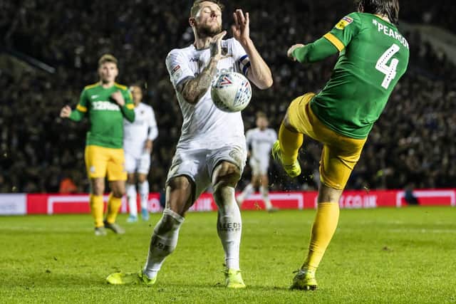 Ben Pearson challenges with Leeds skipper Liam Cooper.