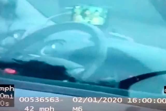 This is the moment a motorist is caught watching TV on the M6 by police