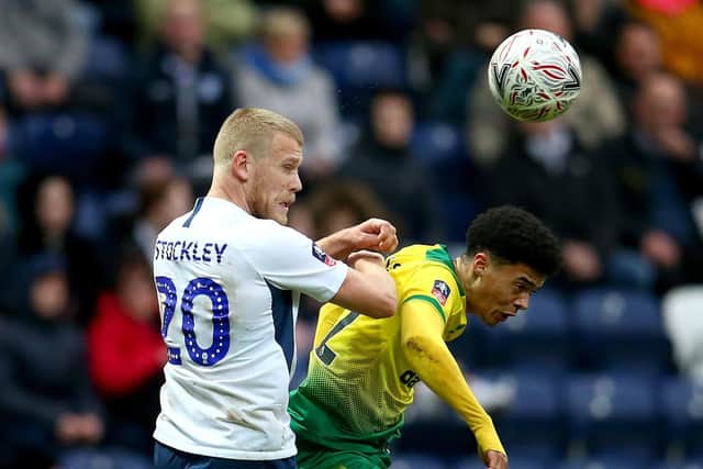Preston striker Jayden Stockley challenges in the air with Norwich left-back Jamal Lewis
