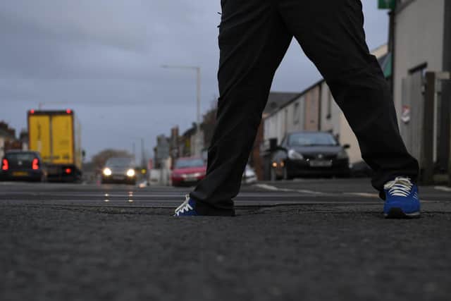 A resident tests out the depth of a Bamber Bridge pothole in Network Rail land.