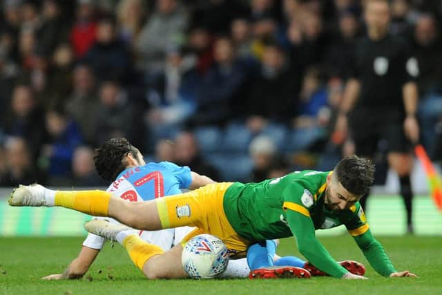 Preston striker Sean Maguire and Blackburn's Lewis Travis challenge on the floor