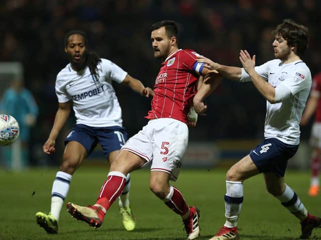 Bailey Wright is challenged by Preston midfielders Daniel Johnson and Ben Pearson at Deepdale in March 2018