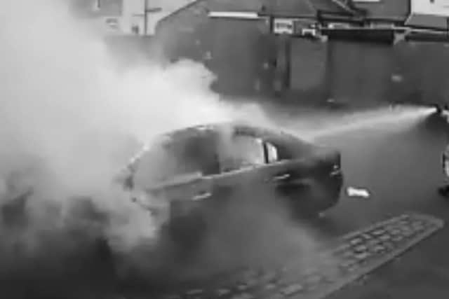 The entire incident, in which a man appears to open a rear door and start a fire inside the car, has been captured on CCTV. Credit: Wayne Richardson