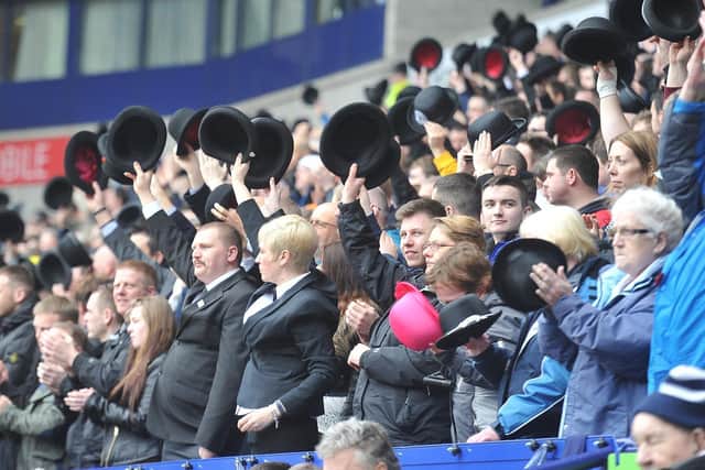 North End fans raise their bowler hats in the stands at Bolton Wanderers.