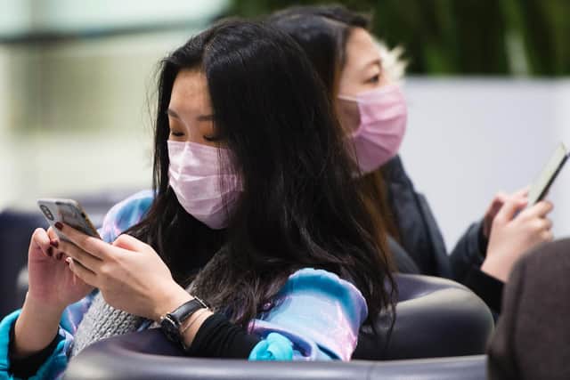 People wear masks following the outbreak of a new virus as people arrive from the International terminal at Toronto Pearson International Airport in Toronto on Saturday, Jan. 25, 2020.