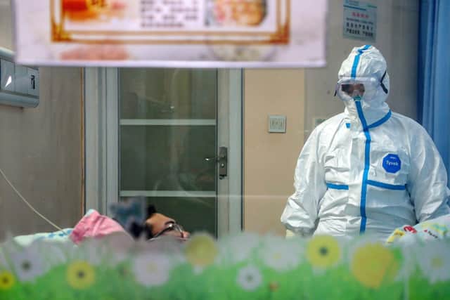 A doctor attends to a patient in an isolation ward at a hospital in Wuhan in central China's Hubei Province