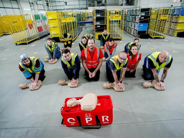 British Heart Foundation trainers Gareth and Helen, teaching Amazon workers how to become CPR trainers
