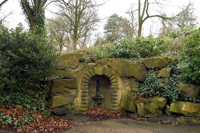 Drinking fountain. Probably c.1865, altered. Sandstone. Coved recess in rock built into embankment.