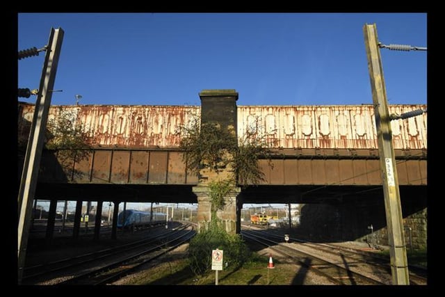 Road bridge over main railway lines. Later 19th century, extended. Sandstone ashlar and cast-iron. Very large rectangular piers, and high parapet of cast-iron panels.