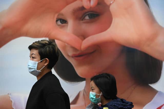 Pedestrians wear face masks in Hong Kong on February 5, 2020, as a preventative measure following a virus outbreak which began in the Chinese city of Wuhan (Photo by Anthony WALLACE / AFP via Getty Images)