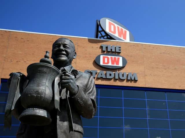 Wigan Athletic legend Dave Whelan holds the FA Cup in a statue to commemorate their remarkable success.