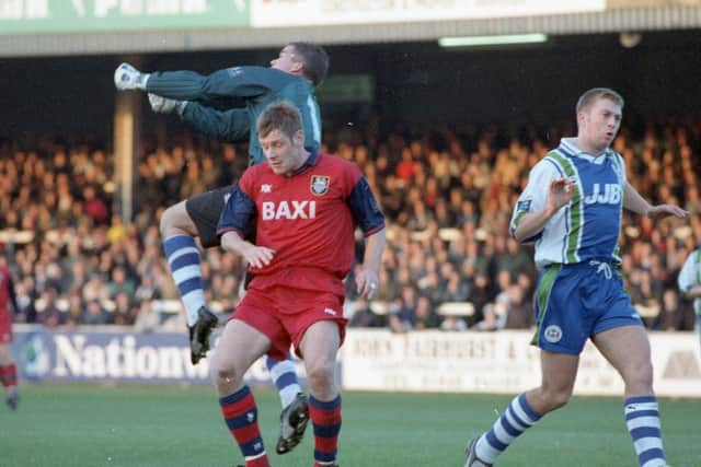 Preston striker Tony Lormor challenges with Wigan goalkeeper Lee Butler