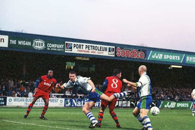 Preston striker Lee Ashcroft challenges with Wigan defenders Pat McGibbon and Colin Greenall