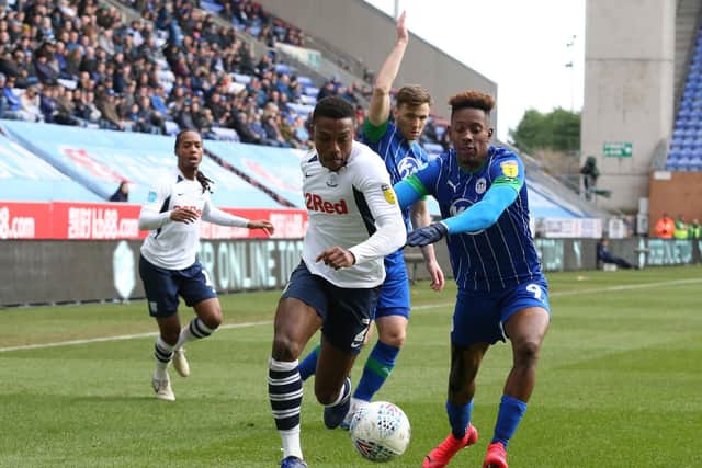 Preston right-back Darnell Fisher escapes the attentions of Wigan striker Jamal Lowe