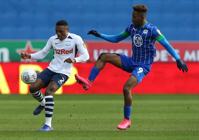 Darnell Fisher shields the ball from Wigan striker Jamal Lowe at the DW Stadium