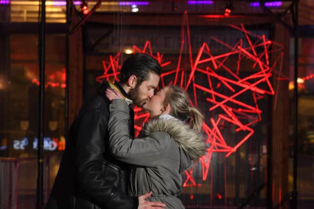 Drew Noon and Anna Miller get romantic in front of the Heartbeat art installation at Preston Market