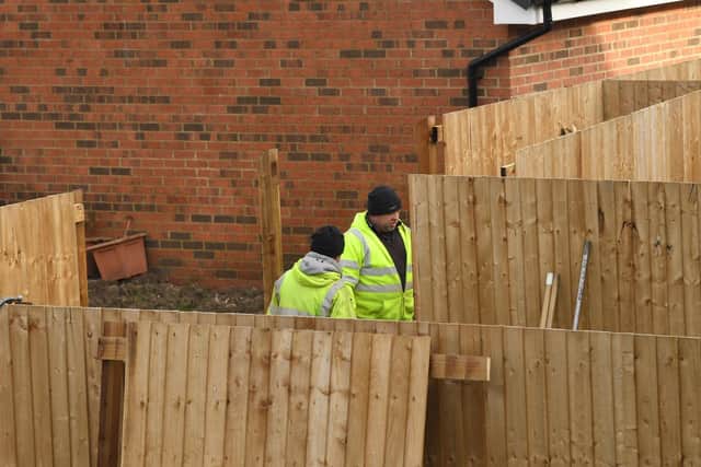 Workmen moving fencing at the back of homes in Harvester Drive.