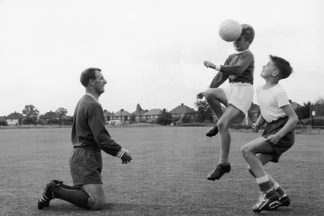 Chelsea FC manager Tommy Docherty watches his son 11-year-old Michael training with a schoolfriend, Christopher Clark, in Ewell, Surrey, 23rd July 1962. Michael later followed his father into football. (Photo by Central Press/Hulton Archive/Getty Images)