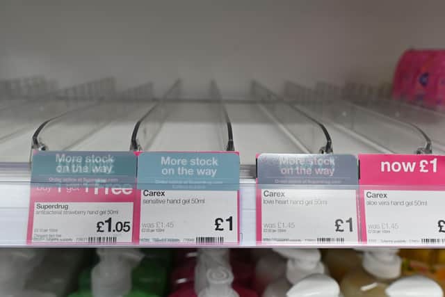 A picture shows empty shelves where hand sanitiser gels have sold out in a drug store (Photo by JUSTIN TALLIS/AFP via Getty Images)