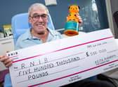 'Sooty Man' Keith Ainsworth with his cheque and Sooty collection tin. Photo: Kelvin Stuttard