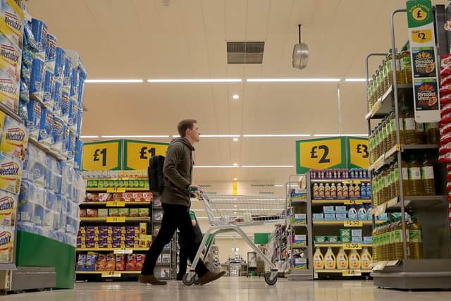 Shoppers buy groceries and goods inside a Morrisons supermarket