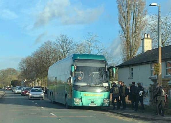 Pupils boarding a coach, parked on the zig zag lines