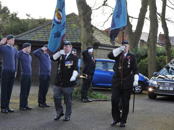 Standard bearers lead the funeral cortege for John Valentine as cadets look on.