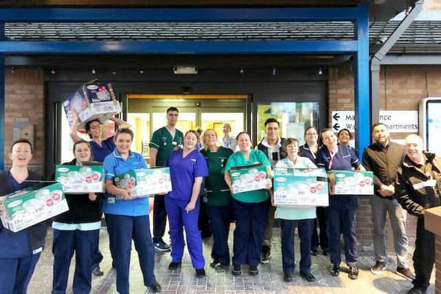 Chorley Hospital staff receive free food from Shiraz Miah (seventh from right) after he temporarily closed his Thindian takeway in Leyland