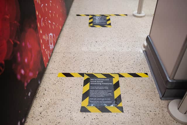 Make-shift signs on the floor of a supermarket, identify how far apart customers should stand while queueing in a bid to respect the social distancing guidelines  (Photo by Leon Neal/Getty Images)