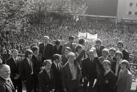 Preston North End's 1970/71 Third Division title-winning squad on the steps of the Harris Museum with thousands of PNE fans on the flag market below
