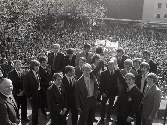 Preston North End's 1970/71 Third Division title-winning squad on the steps of the Harris Museum with thousands of PNE fans on the flag market below