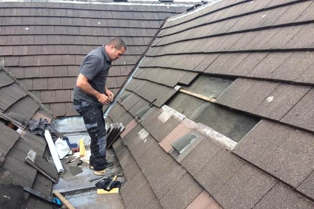 Good Samaritan Lee Schofield fixing the roof of the store. (Credit: Derian House)