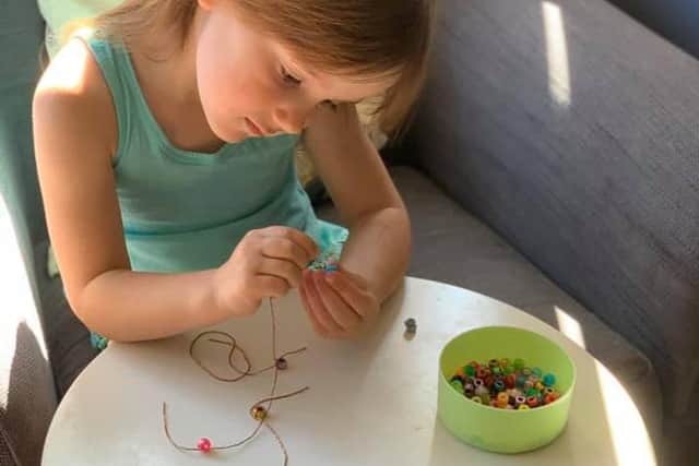 Arabella making her bracelets.