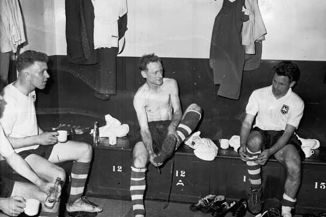 Sir Tom Finney taking his boots off after his final game for Preston North End
