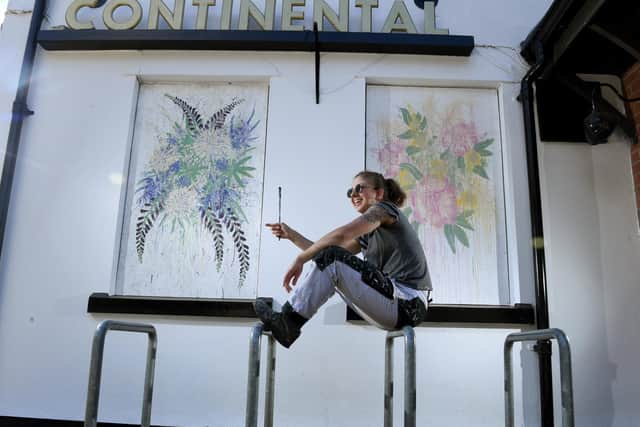 Artist Hannah Browne pictured with her murals at The Continental