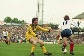 The PNE away following can be seen behind Mark Leonard as he fails to stop the run of a Bolton player