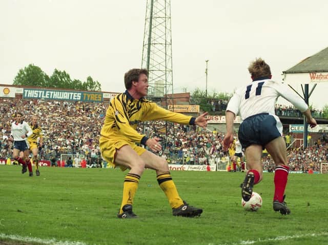 The PNE away following can be seen behind Mark Leonard as he fails to stop the run of a Bolton player