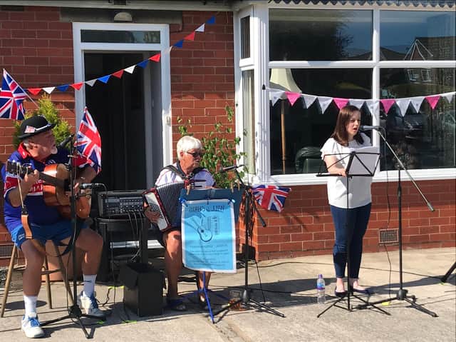 Elizabeth Singleton sings with Chris and Will Lingardduring the VE day outdoor performance