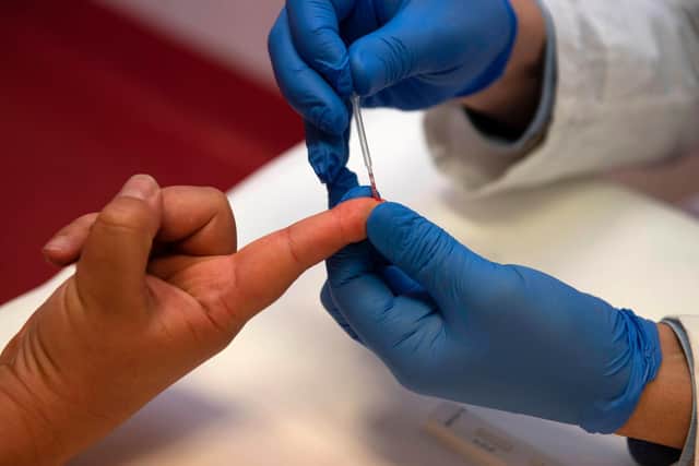 A person undergoes a finger prick blood sample as part of of an antibody rapid serological test for COVID-19 in Italy