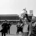 Derby County manager Brian Clough (left) and his assistant Peter Taylor show off the League Championship trophy to the jubilant Derby fans who had packed the Baseball Ground in 1972