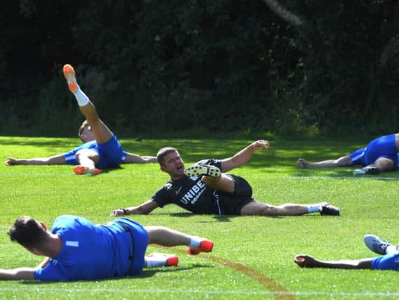 PNE fitness coach Tom Little leads a stretch session at Springfields during pre-season training last summer - sessions like this are having to be done remotely at the moment