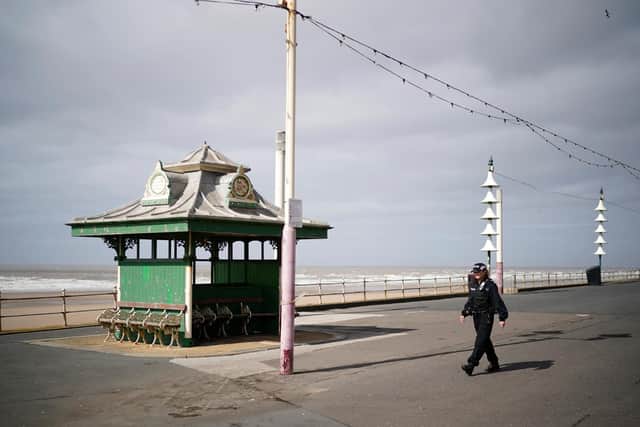 A police officer patrols a deserted seafront in Blackpool.
