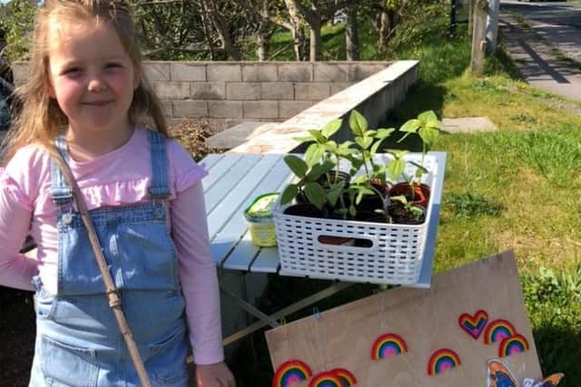 Lilabelle Bibby with her stall outside her home selling rainbows and sunflowers.