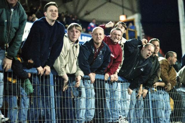 PNE fans climb the fences in readiness to celebrate on the pitch