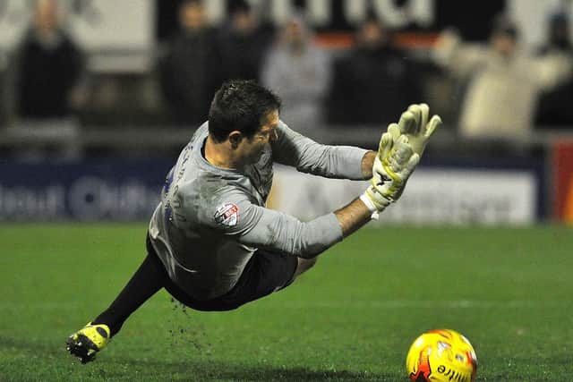 Thorsten Stuckmann saves a penalty in a Johnston's Paint Trophy shoot-out at Oldham in November 2014