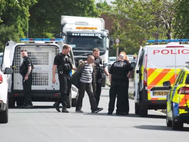 A man is led away in handcuffs after the stand-off ended.