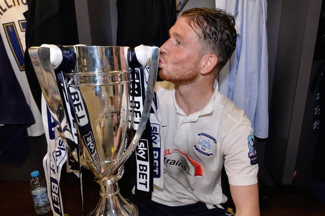 Preston striker Joe Garner kisses the play-off winners trophy in the Wembley dressing room