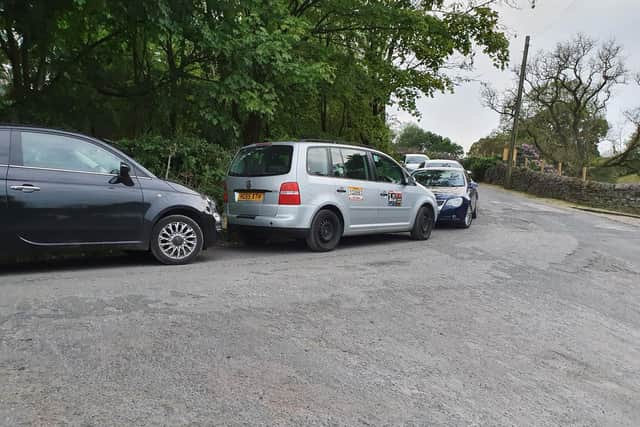Cars blocked the narrow road with their parking.