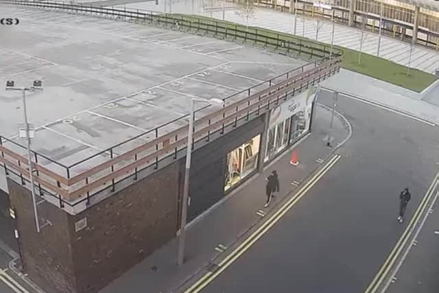 The footage shows two people walking down a streetbefore one of them stops tovandalisea nearby wall. (Credit: Lancashire Police)